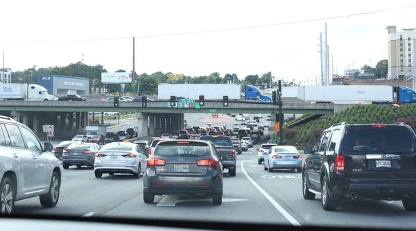 tucker car accident lawyer - Heavy traffic on a multi-lane road under overpass in Tucker, Ga with green lights visible. 