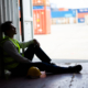 Anguished factory worker sitting next to a cargo container - is emotional distress a personal injury