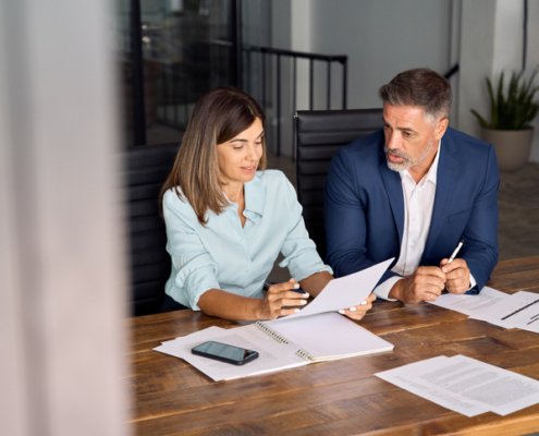 two people having a discussion while reviewing documents - why is causation difficult to prove?